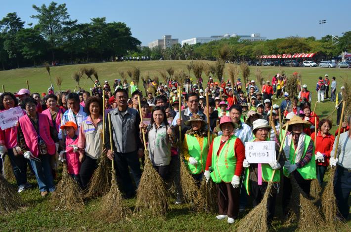 縣府參議吳登林、環保局副局長林武宏與社區環保志工拿著掃把清掃街路