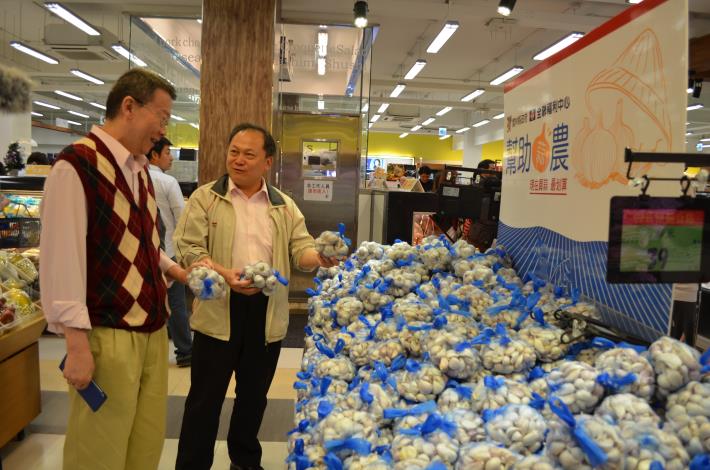 縣府農業處企劃行銷科長林俊明在協助促銷蒜頭