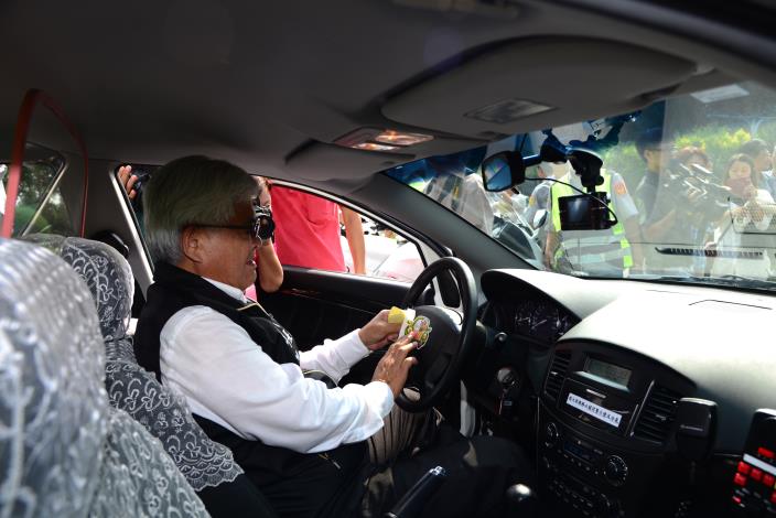 李縣長在巡邏車方向盤上貼上「點亮車頭燈、安全加倍增」提醒小貼紙