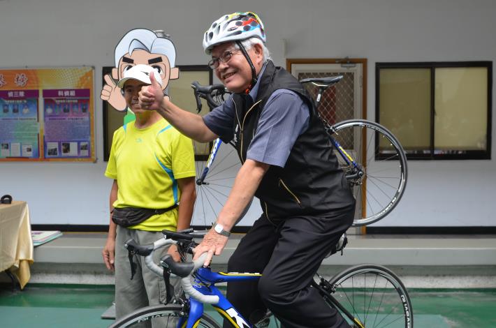 李縣長示範騎腳踏車要戴安全帽、並在車體上黏貼反光條