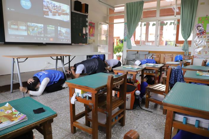張縣長與斗六國小師生一起做「趴下、掩護、穩住」動作，進行地震避難掩護演練。