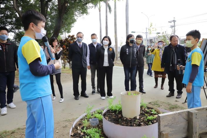 張縣長與來賓一起參觀獲臺美生態學校銀獎認證的廉使國小校園，聽取學生介紹生態菜園。