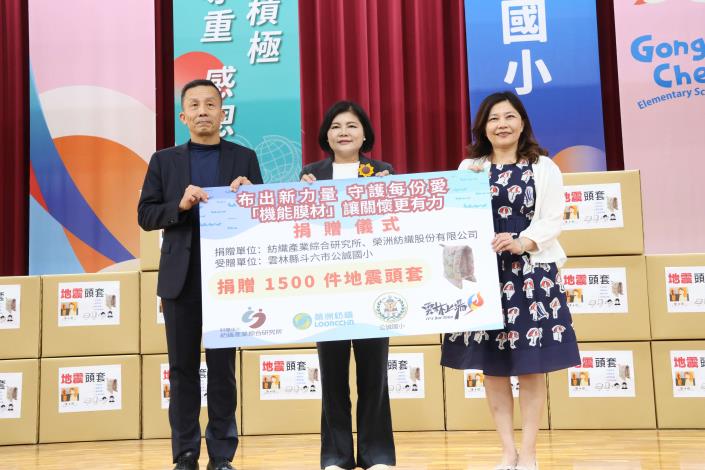 由紡織綜合所黃博雄協理贈送1500頂地震防護頭套予蔡宜芳校長,並由蔡校長代表全體師生致上感謝狀表達謝意,張縣長見證