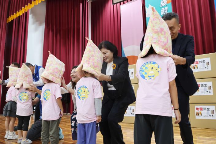 張縣長等貴賓們一一為學童們穿戴上震防護頭套